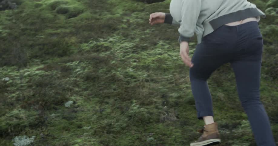 A woman runs jumping over the rocky terrain