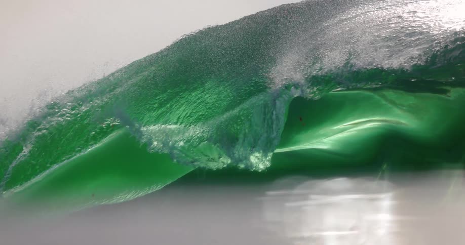 A wave crashes down into the water