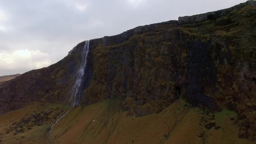 A waterfall falls off the side of this tall mountain