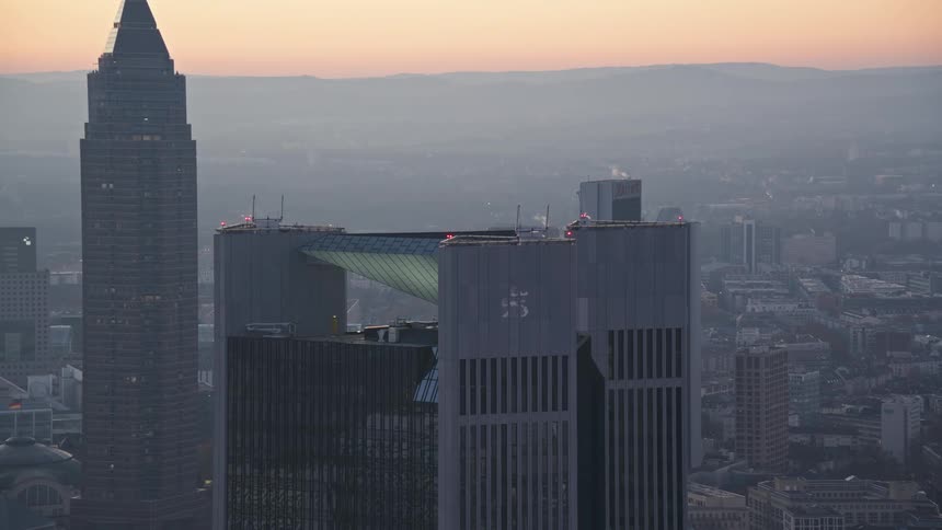 Fog covers the city as red tints the sky