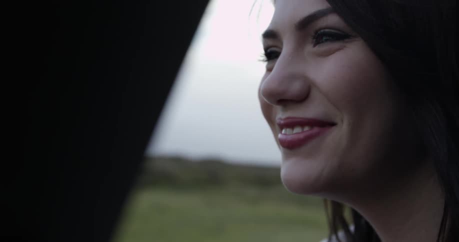 A woman smiles as the wind blows her hair