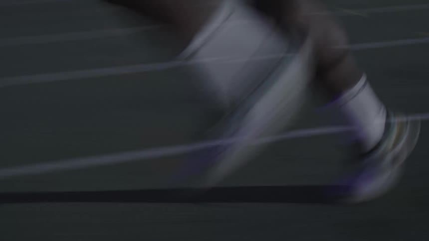 Legs of a person running on an athletics track