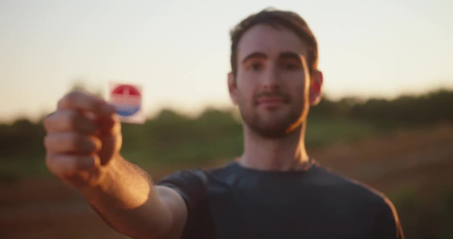 A man holding a sticker outdoors