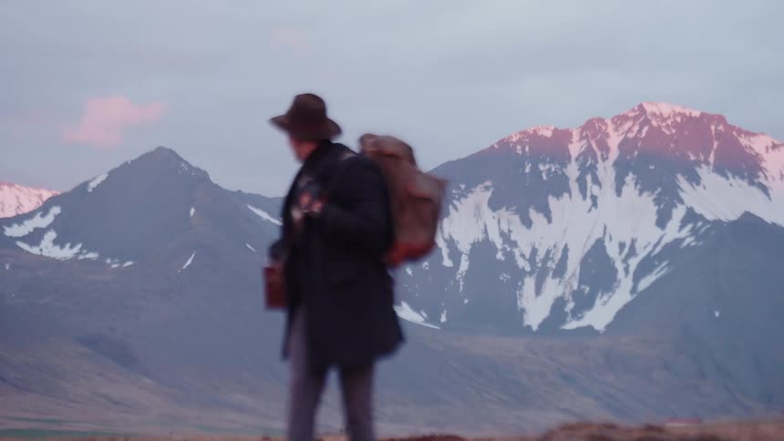 A man hiking outdoors through a field during daytime