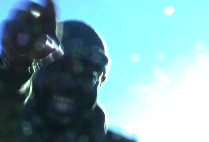 A man smiles and makes excited gestures while walking outdoors