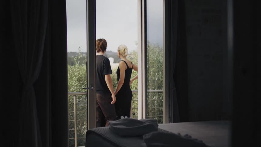 Man and woman standing on the balcony talking