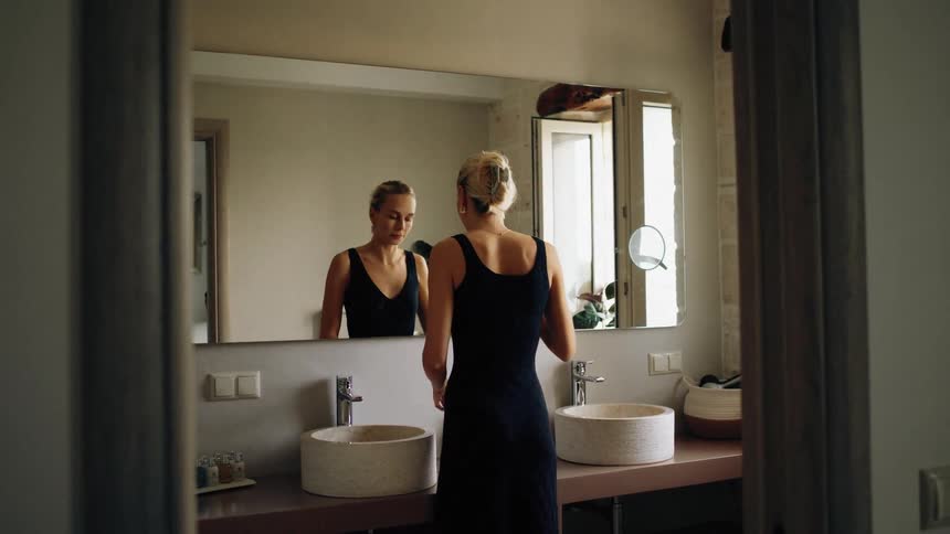 Woman standing in the bathroom puts on makeup
