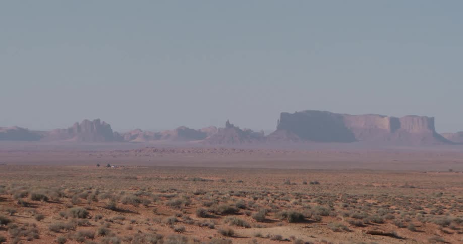 Haze covers the mountains and plateaus bordering arid terrain