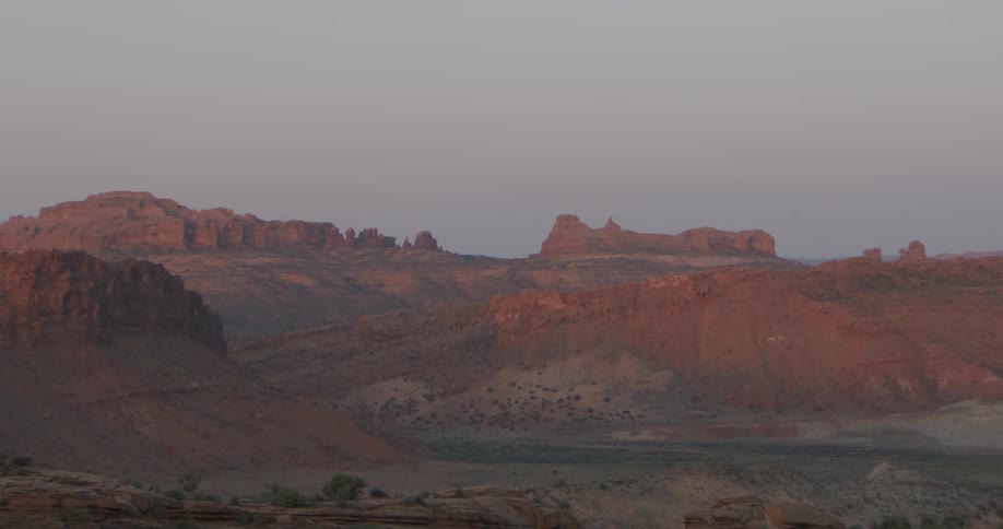 Extensive rock formations with arid terrain under soft dusk light