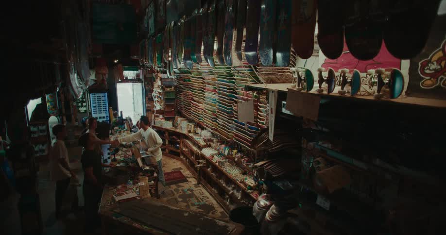 Skate shop with shelves filled with decks and accessories while customers interact at the service counter