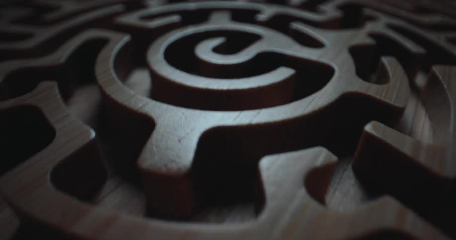 Circular wooden maze with interconnected grooves and raised paths