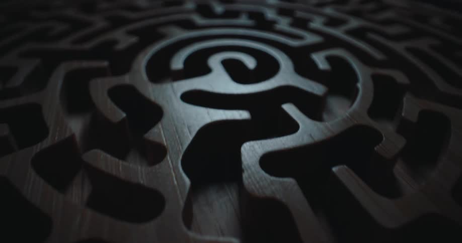 Dark wooden circular maze with a spiral pattern and light contrast