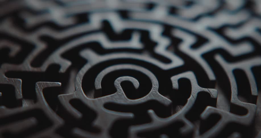 Dark wooden circular maze with a spiral pattern and precise cuts