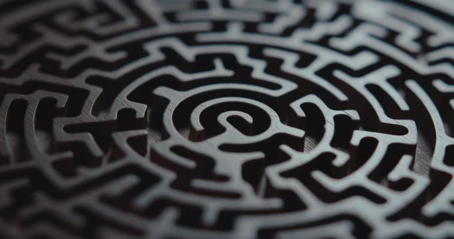 Light shines on a three dimensional labyrinth carved on a round disk as it turns