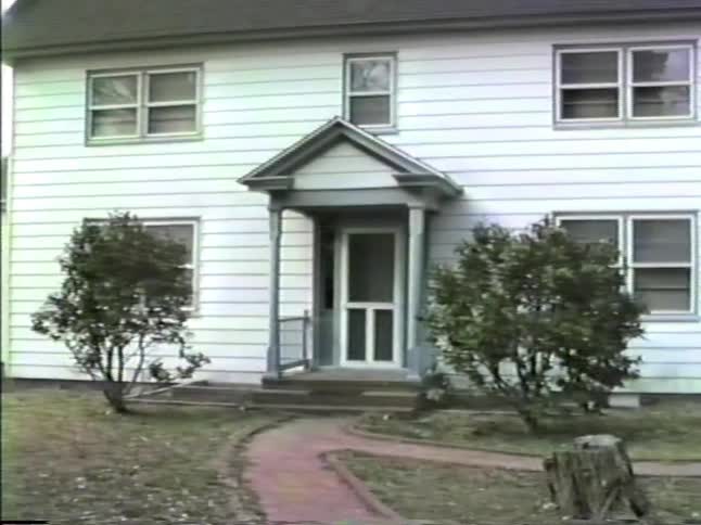 A blinking video calibration message appears on a tape of a twostory white house