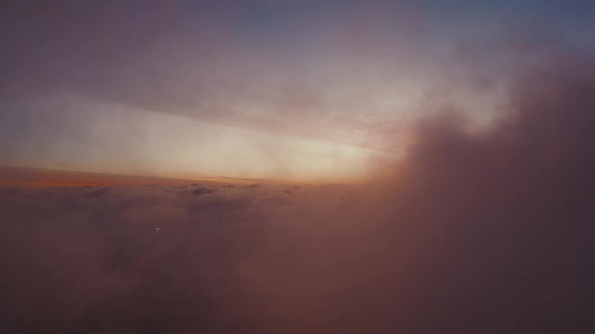 Cloud layer seen from above under a dawn sky with light on the horizon