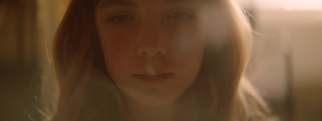 Closeup of a young girls face illuminated by warm gentle light indoors
