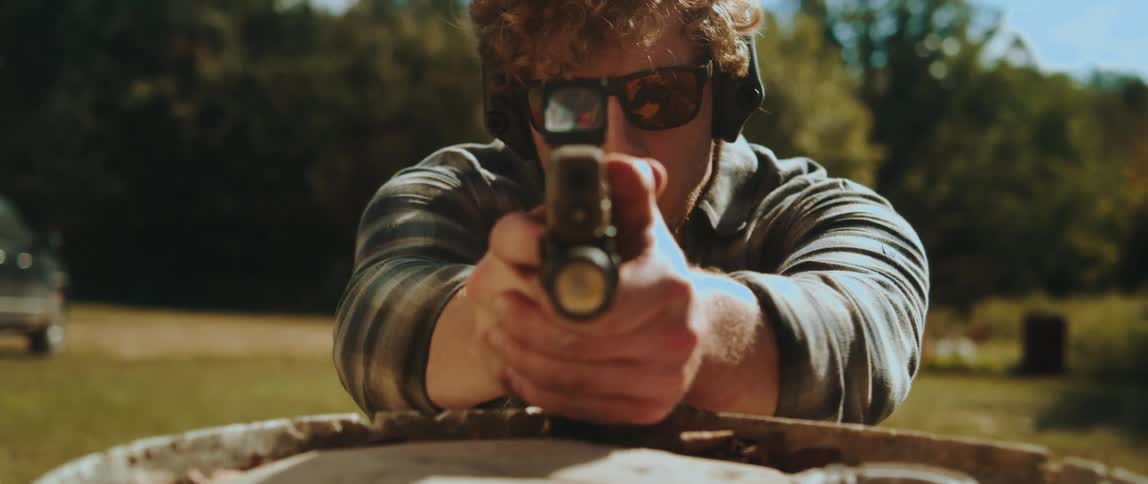 The man pulls out his gun and aims