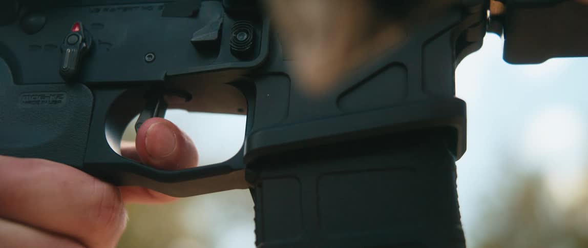Finger pressing the lever of a rifle