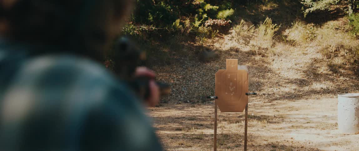 Shooter fires at a cardboard target set up at an outdoor range