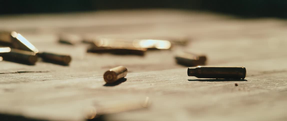 Metal cartridges scattered across a flat surface under direct lighting