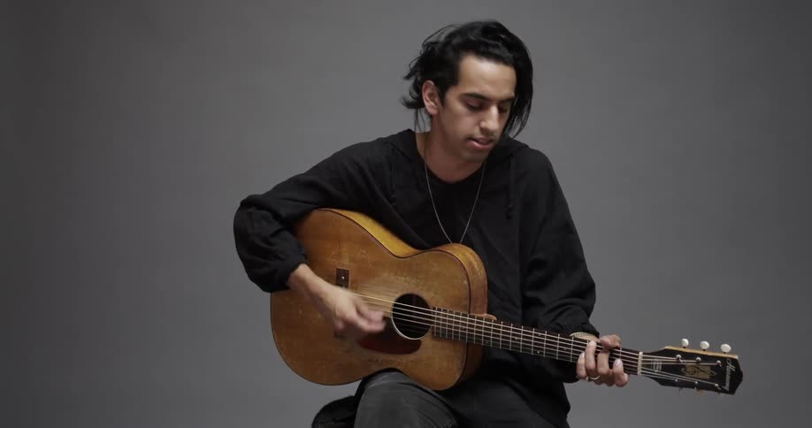 A man plays the guitar while singing