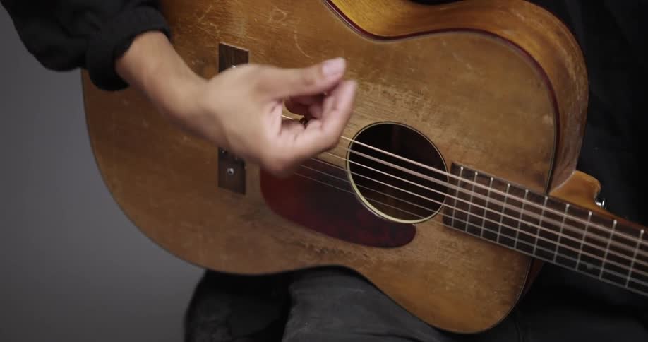 Close up of a person strumming an acoustic guitar