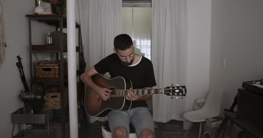 A man plays guitar bobbing his head