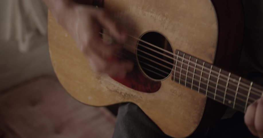 A man is playing his guitar