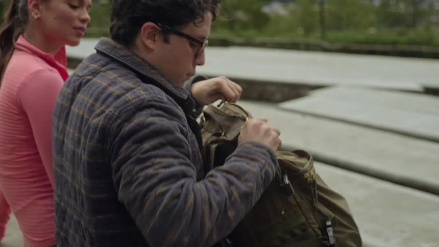The man opens up his backpack
