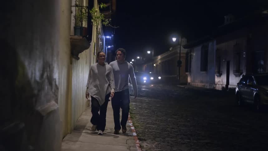 A couple people walking down a sidewalk