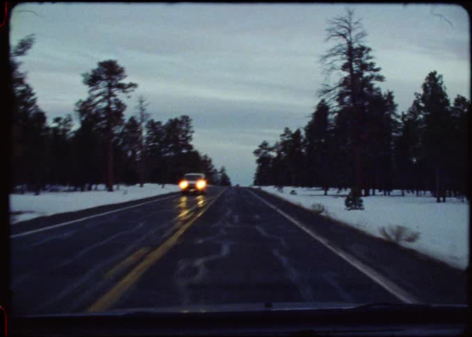 Moving view along a highway surrounded by trees and snow