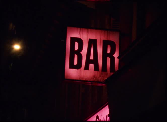 Bar sign glows outside of a bar at night