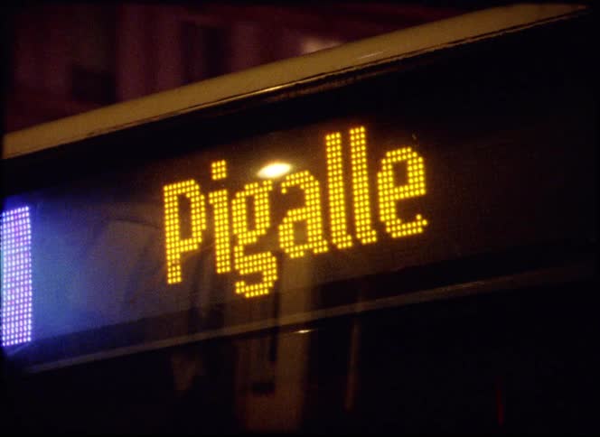 The bus is on the city street at night
