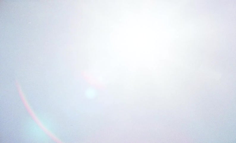 A view of some clouds and the sun in the sky