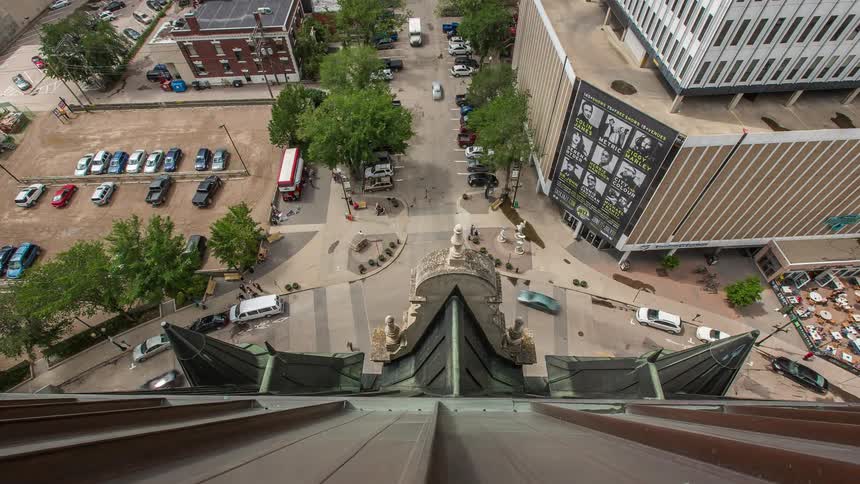 Cars move around the road in front of a tall building