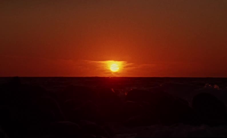 A scenic view of the sun setting over the ocean