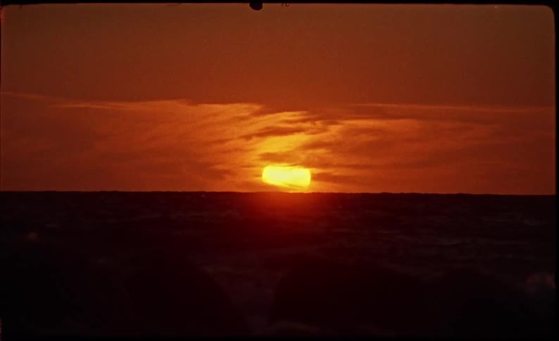 Seascape with the reddish sun on the horizon