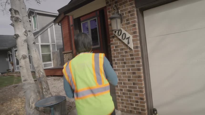 A delivery driver dropping off a pacakge at a house