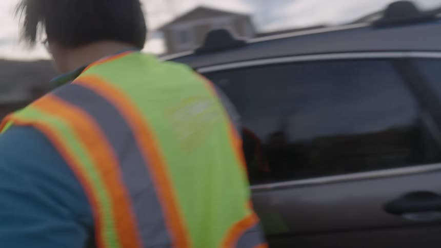 Man in reflective vest running into a car