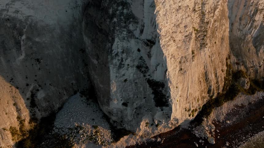The side of the mountain has rubble at the bottom