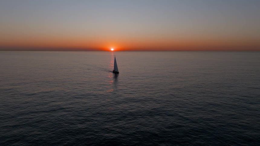 The boat is sailing as the sun rises