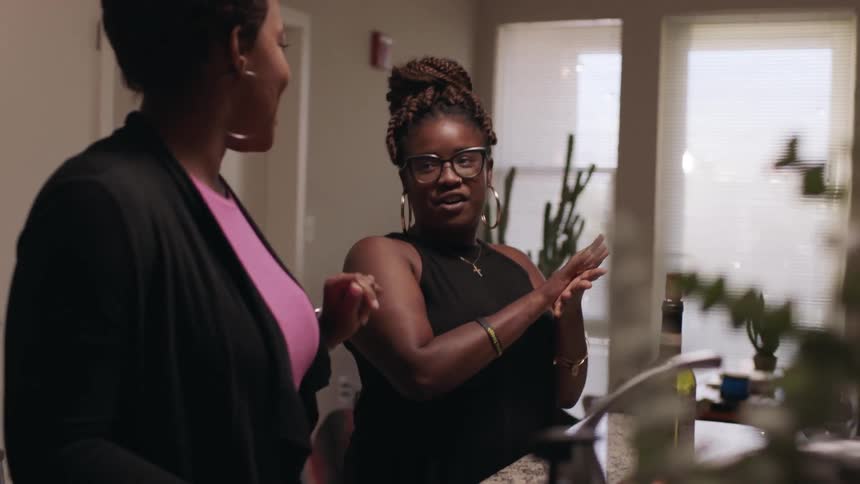 Women talk and wave their hands around