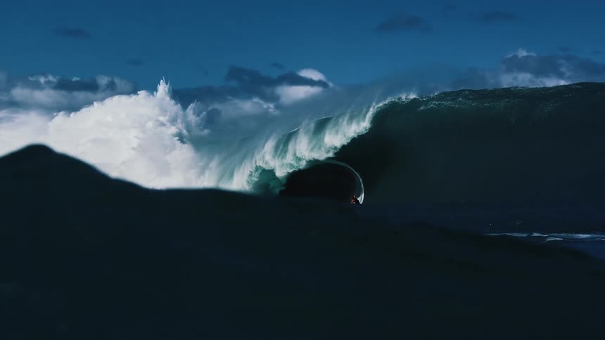 The surfer is riding a very tall wave