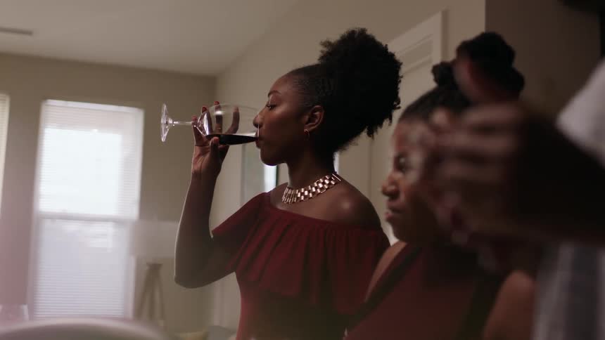 A woman takes a drink as she spends time at a party