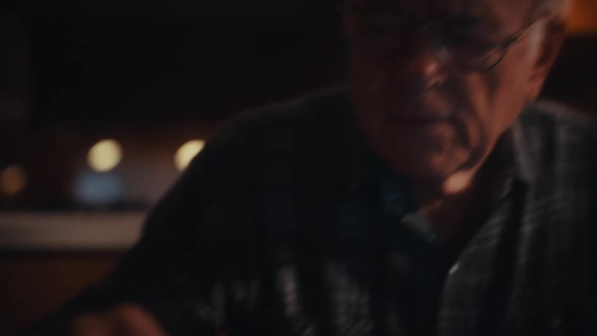 Elderly man sitting using a calculator