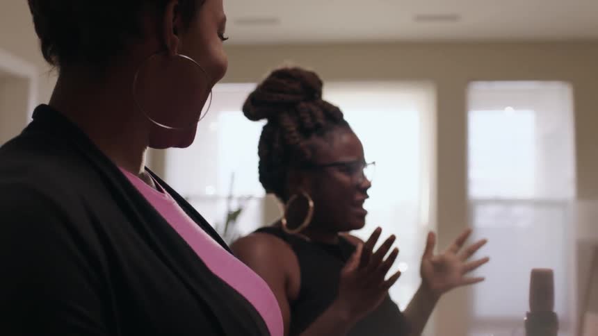 A woman talks and waves her hands around smiling