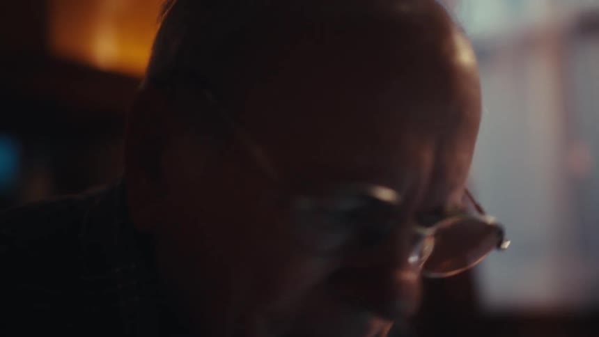 Elderly man typing on a calculator