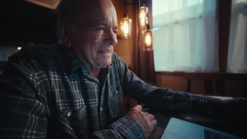 A man sitting down and using a laptop