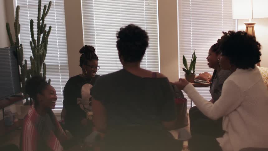 A group of women are gathered in a living room